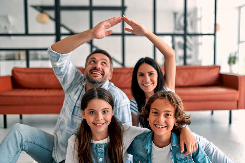 Familia feliz en un hogar sonriendo.